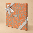 Forrey & Galland Toile de Jouy chocolate gift box, 36 pieces, closed orange and silver patterned box with satin ribbon, champagne background