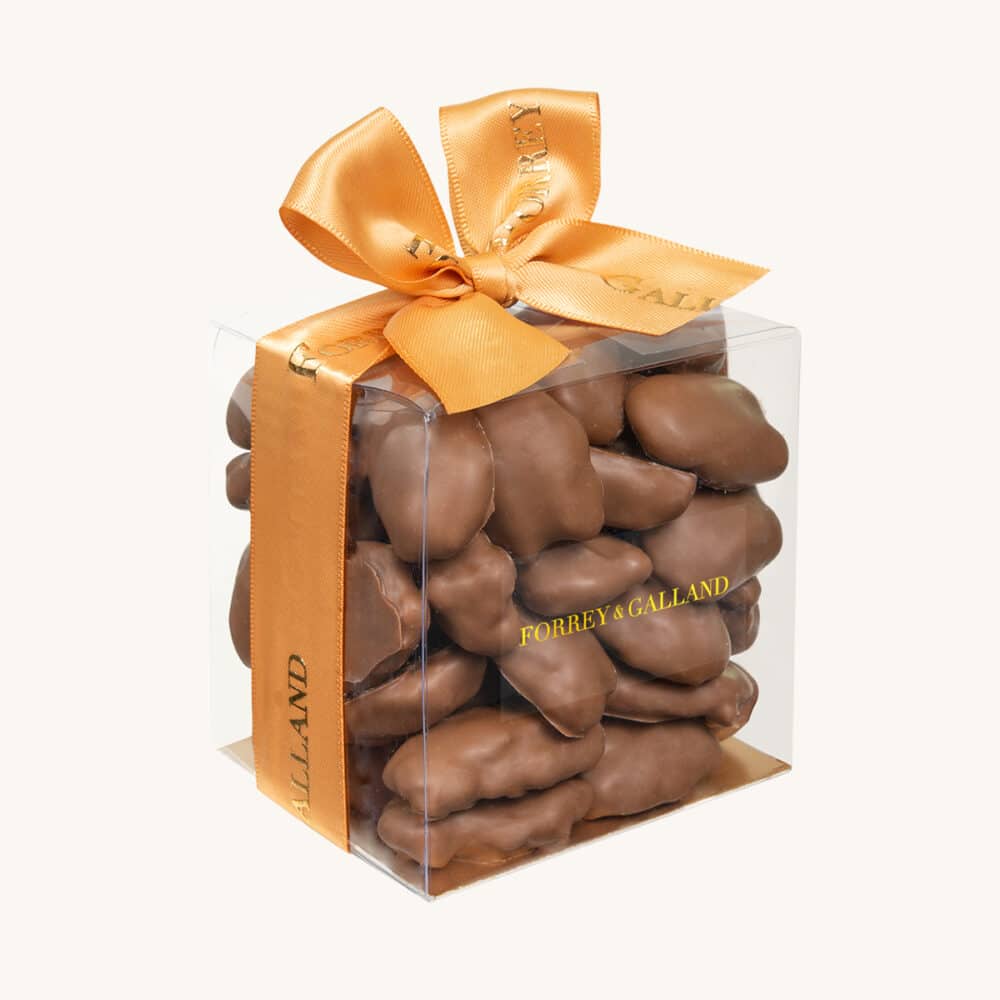 Chocolate pecan nuts in a transparent gift box.