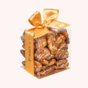 Forrey & Galland artisanal pecan nuts in a transparent gift box with a ribbon.