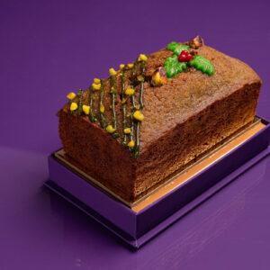 Forrey & Galland Pistachio Cake topped with crushed pistachios and chocolate drizzle