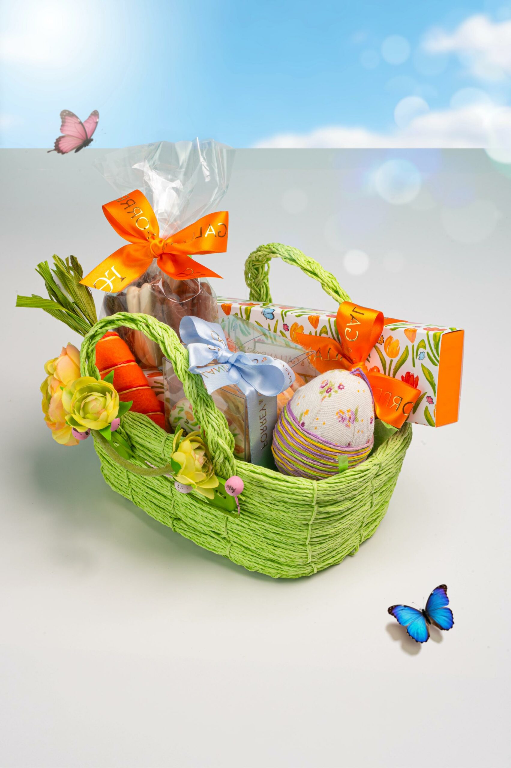Luxury Easter hamper in a green woven basket with floral sleeve box handcrafted chocolates and seasonal treats